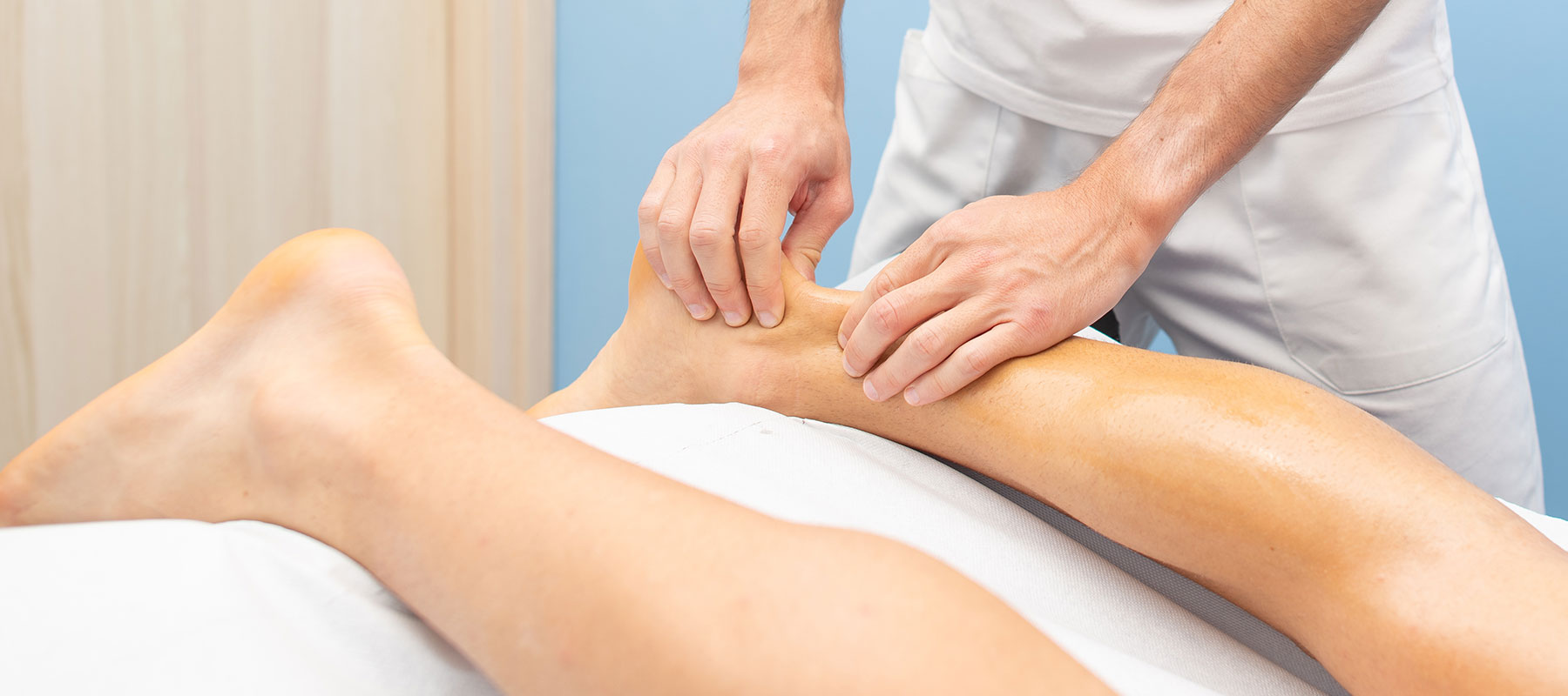 Orthopäde untersucht Achillessehne bei Patient in OCS Düsseldorf