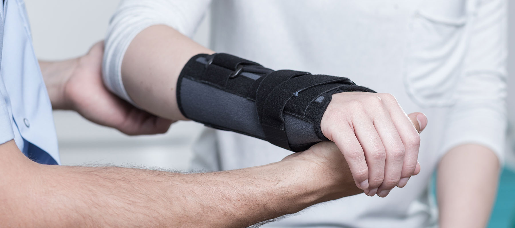 Orthopäde untersucht Hand eines Patienten in OCS Düsseldorf