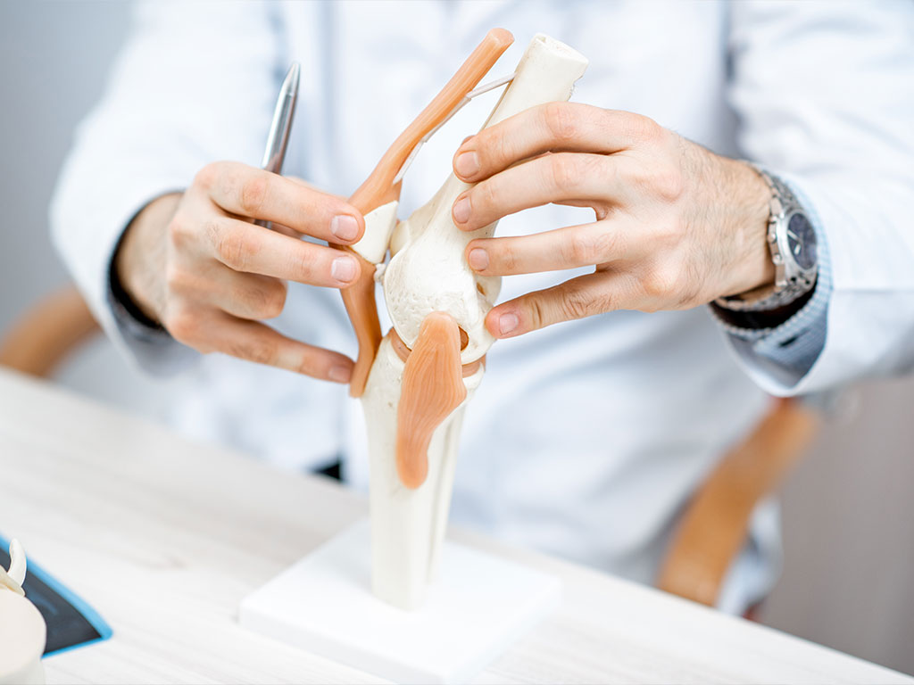 Orthopäde erklärt Symptome der Kniearthrose bei Patient in OCS Düsseldorf
