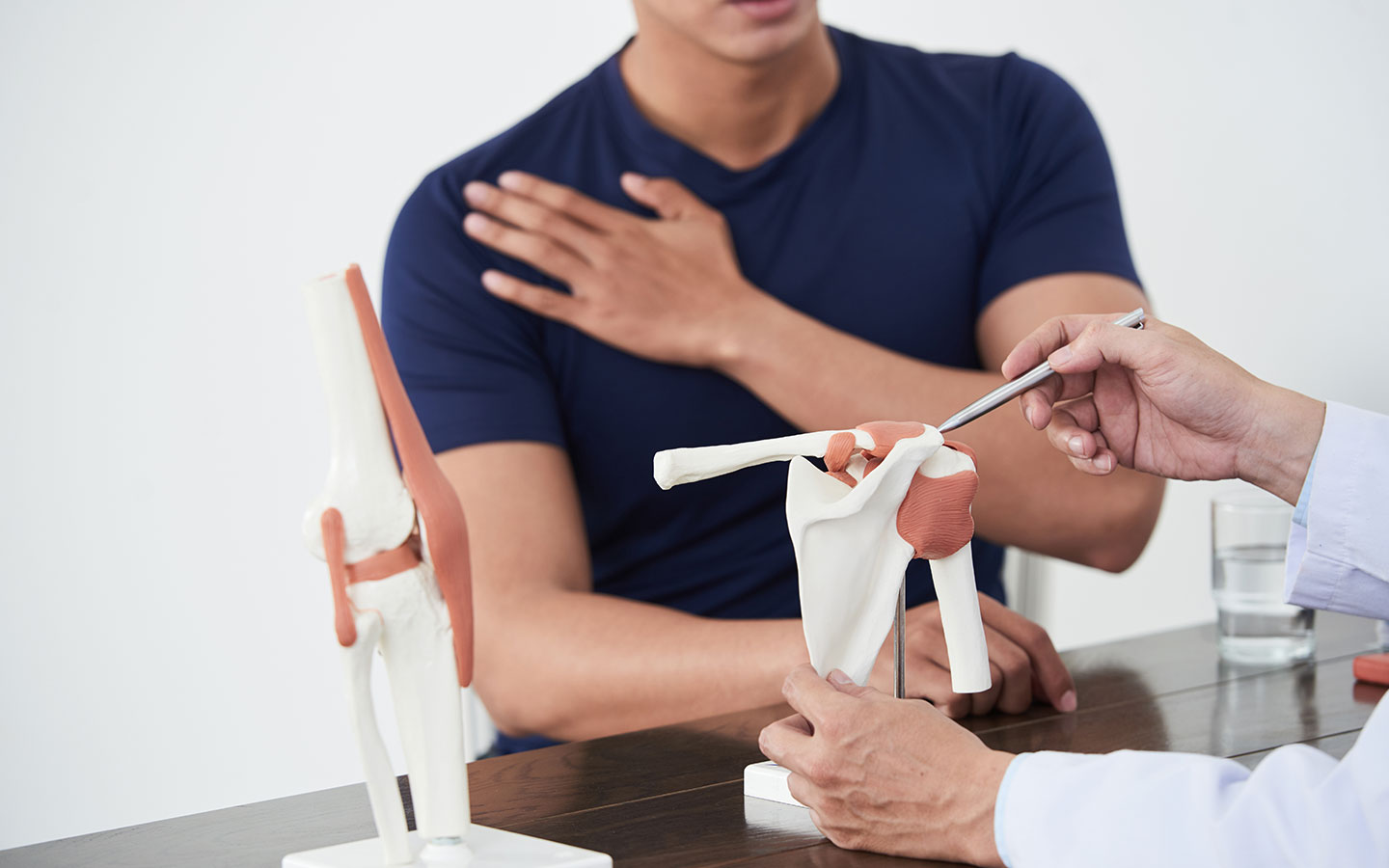 Orthopäde erklärt Symptome von Schulterschmerzen bei Patient in OCS Düsseldorf