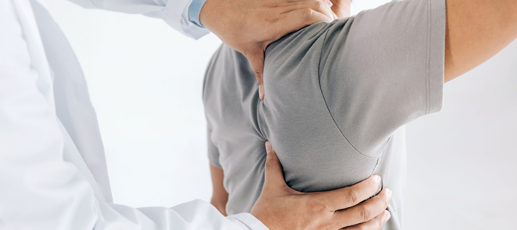 Orthopäde erklärt Rückenschmerzen und Symptome bei Patient in OCS Düsseldorf